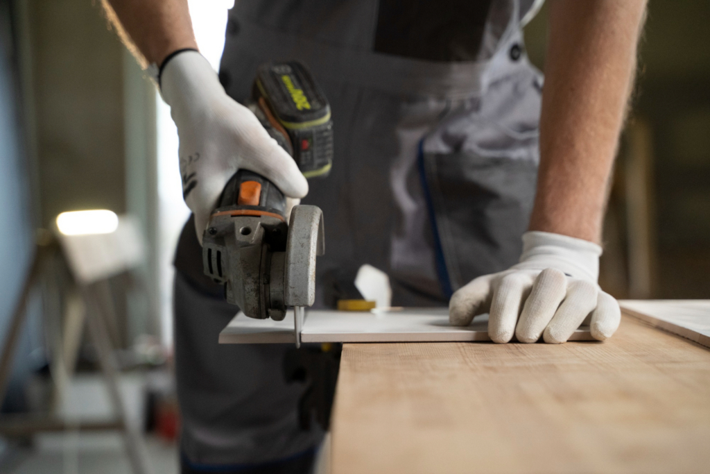 Man using a cut-off tool to cut through a tile. Photo by freepik (Magnific)