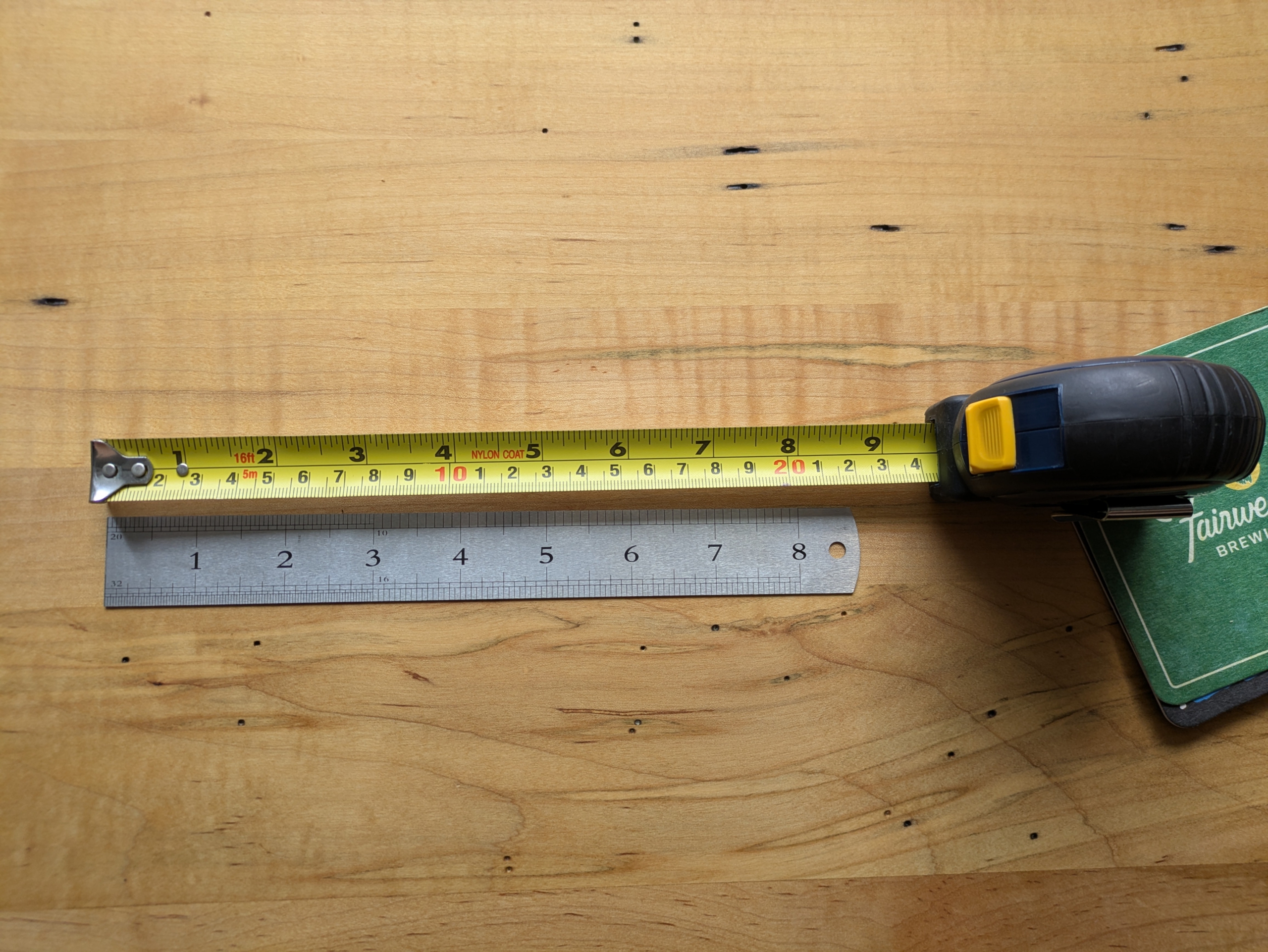 A yellow measuring tape with both imperial and metric measurements, and a silver metal ruler with imperial units.