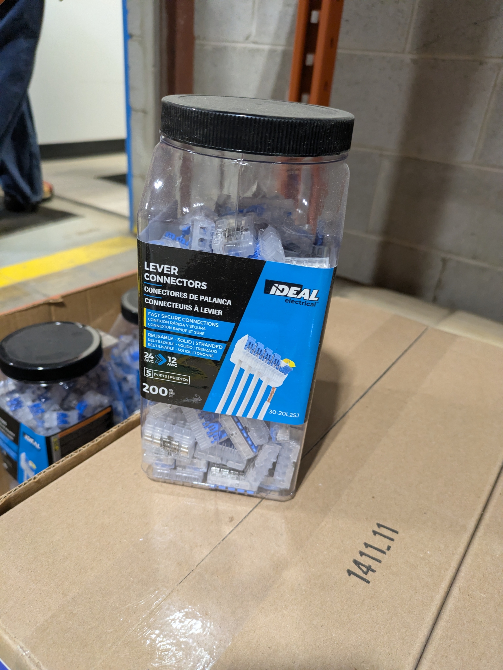 A plastic jar of IDEAL lever connectors. Clear plastic with a blue lever.