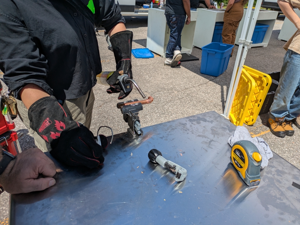 Copper pipe being heated with a blow torch and soldered