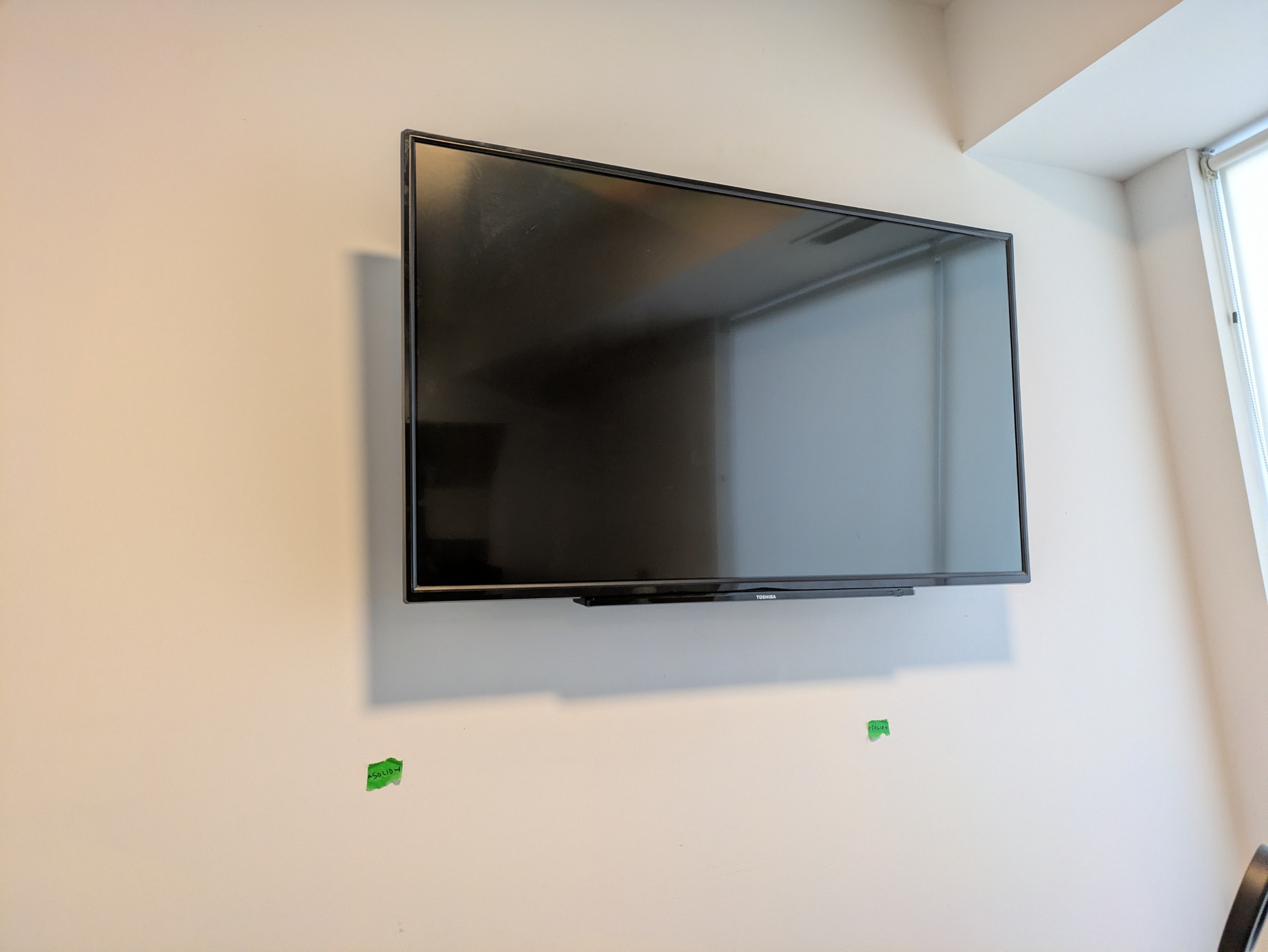 TV mounted in a wall of concrete and drywall